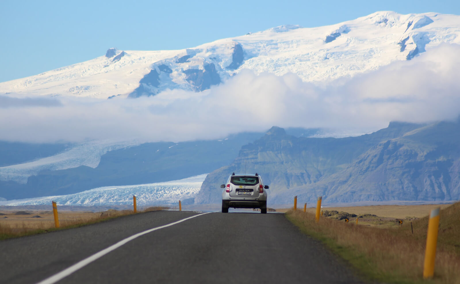 写真：雪山に向かって道路を走る車