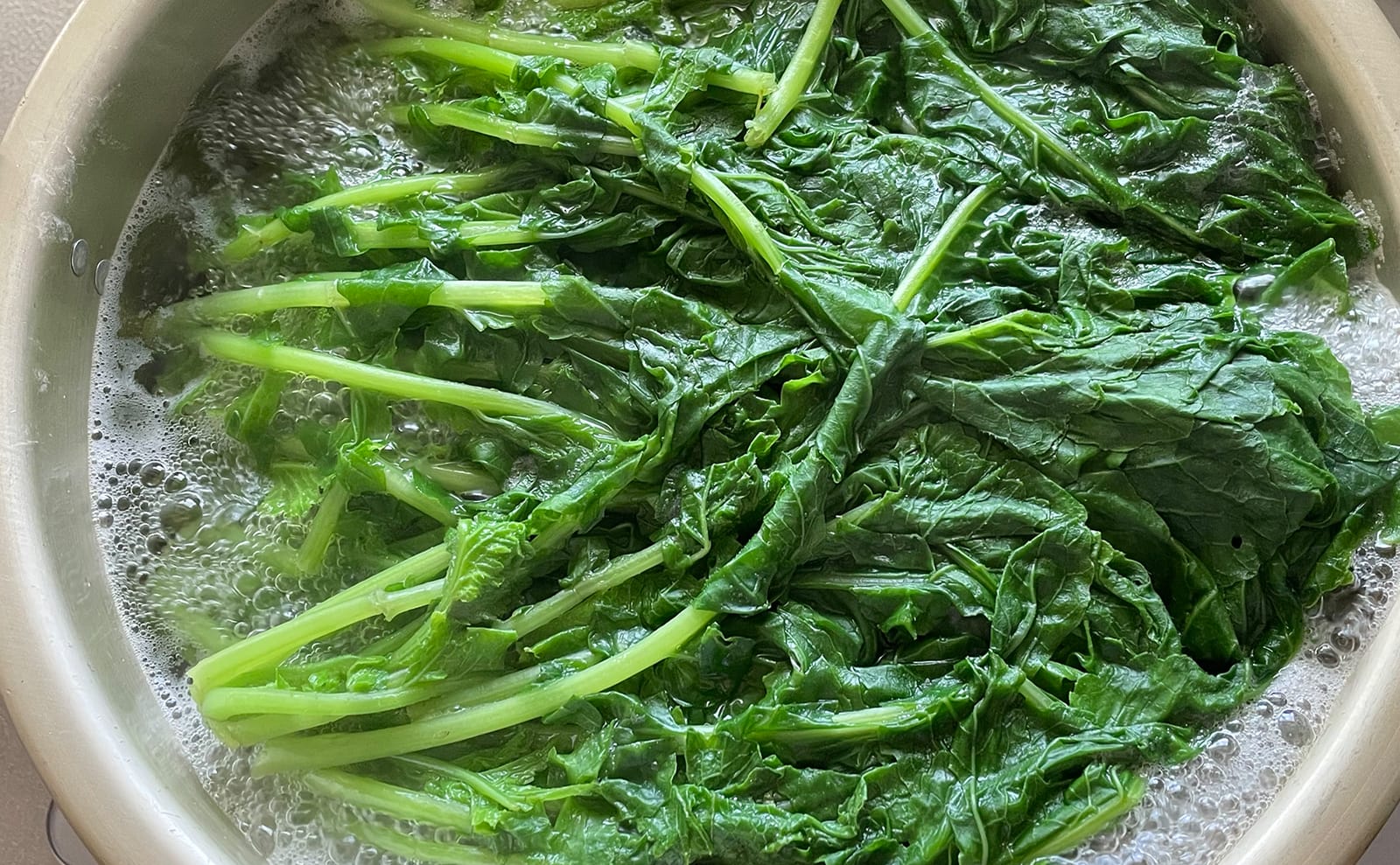 写真：鍋で湯がき中の大根の間引き菜